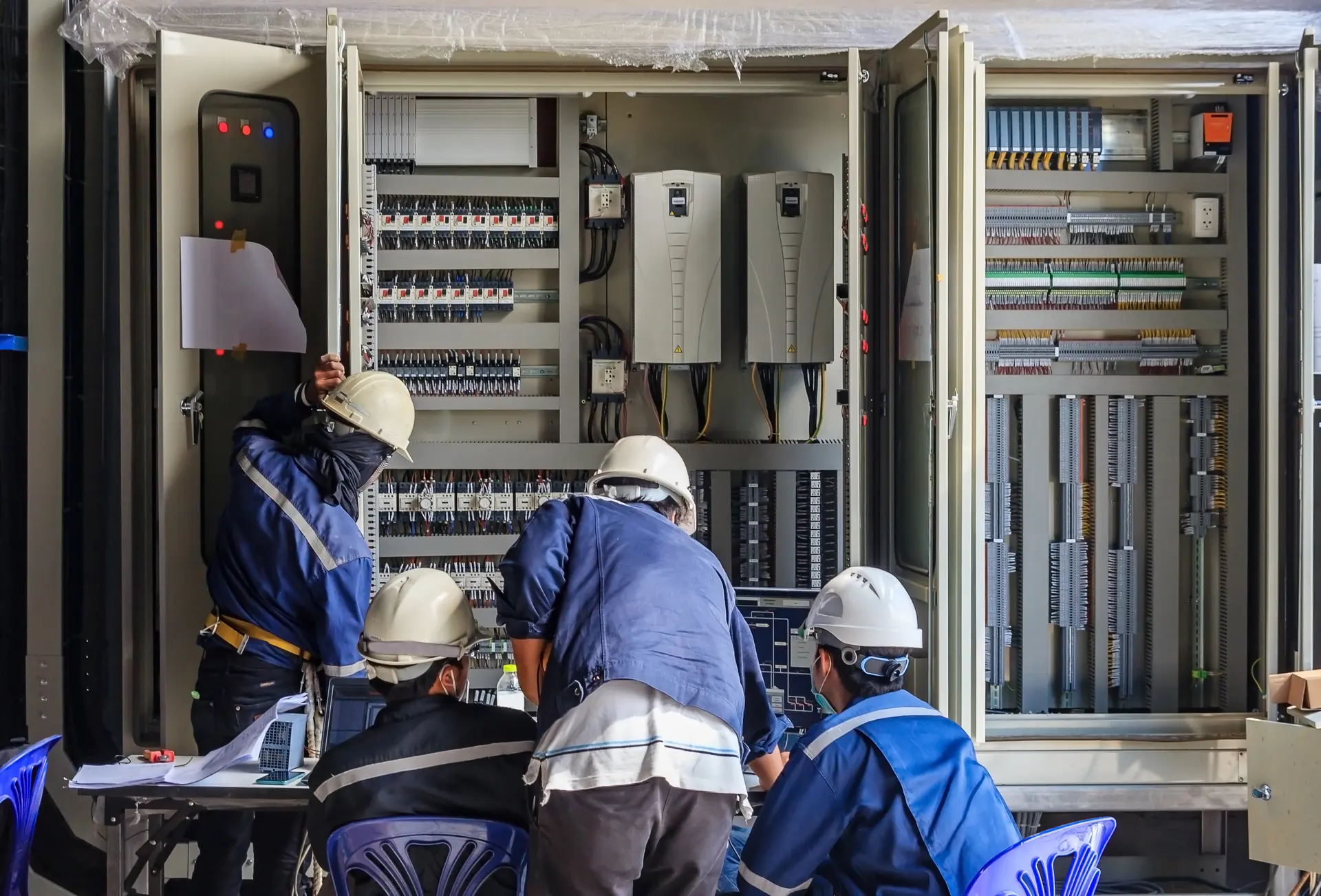 مهندسون أثناء تشغيل واختبار لوحة تحكم كهربائية